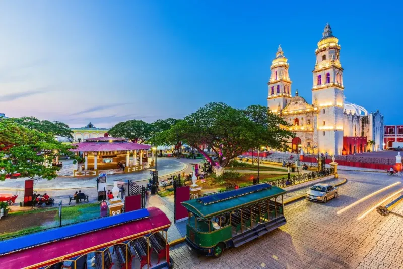 A beautifully lit up church in the main square of a village in Mexico at dusk. Mexico is one of the most relaxed countries with digital nomad visas in the world.