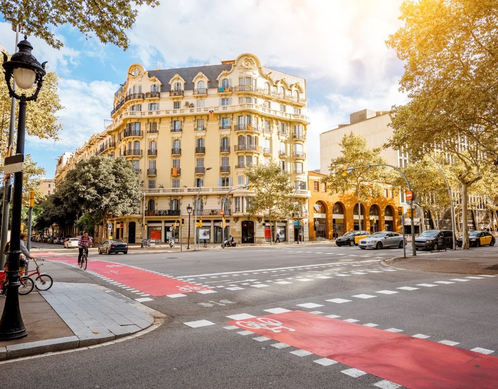 The grand buildings along the streets of Madrid at an intersection in the center of the city on a sunny afternoon.