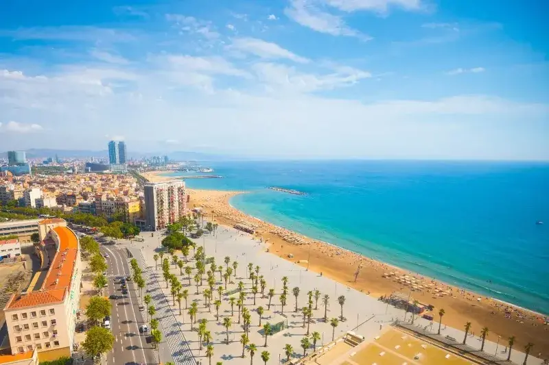 Barcelona's coast line from a birds eye view out towards the turquoise sea on a sunny day.