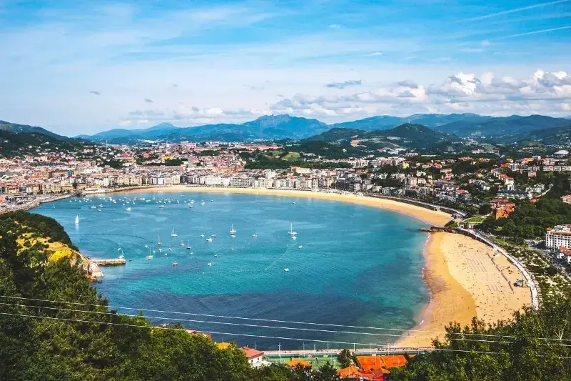 San Sebastian's bay and the sail boats floating in the turquoise water, with the city built right behind the beautiful beach and the mountains beyond.