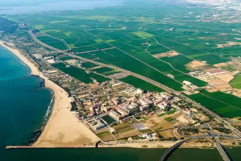 Valencia as seen from a plane looking down on the sandy coastline and the green fields beyond.