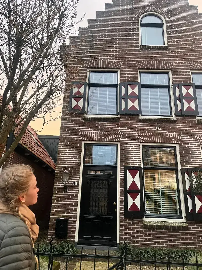 A girl looking at a Dutch house.