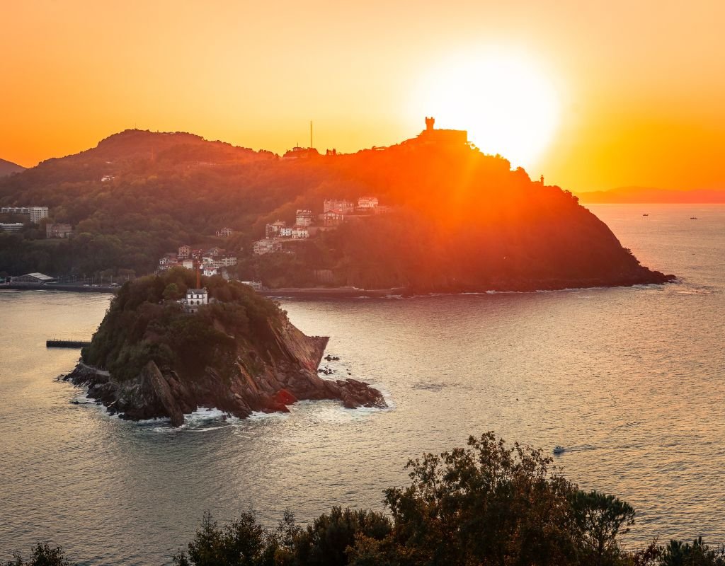 A stunning sunset over the coastline of San Sebastian, with Monte Igueldo and Santa Clara Island bathed in golden light. The perfect view to end a day exploring the city.