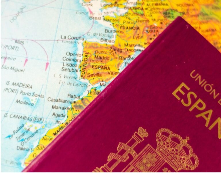 A close-up of a red Spanish passport resting on a map, with Spain and its neighboring countries clearly visible