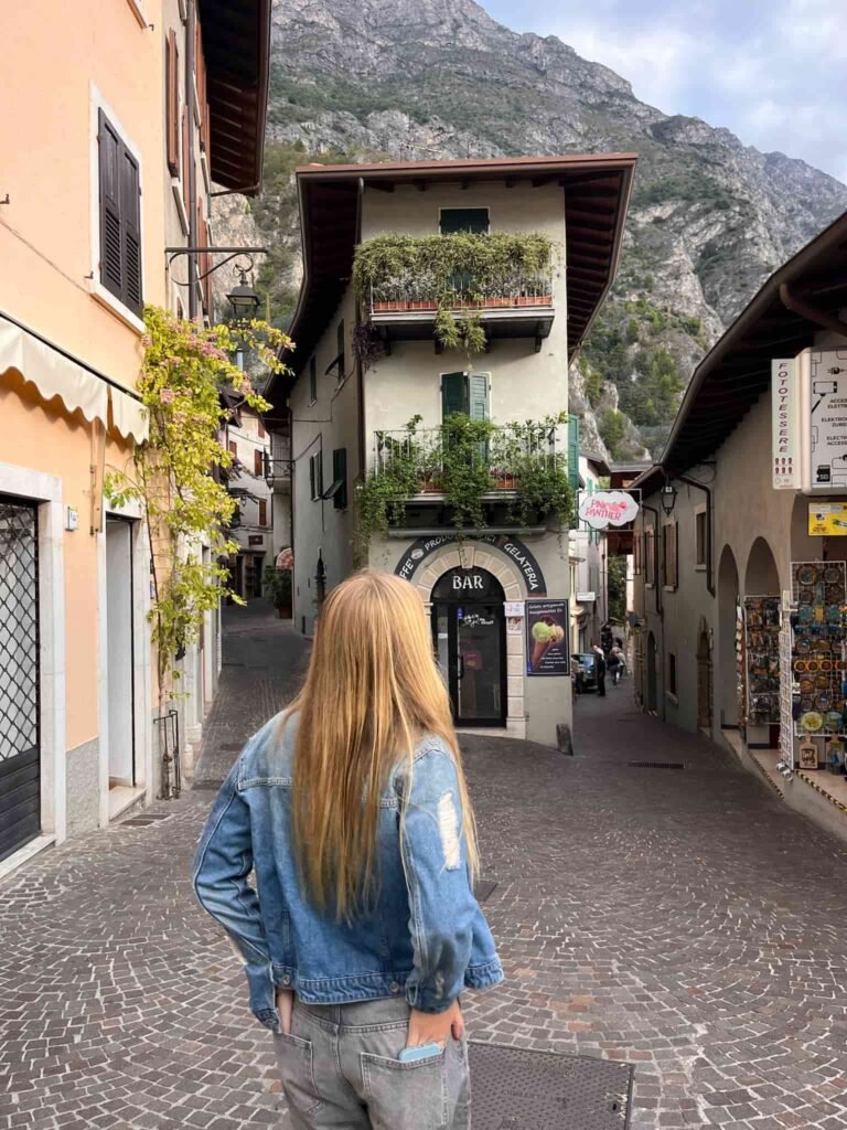 A lady standing in the middle of the street in Limone Italy.