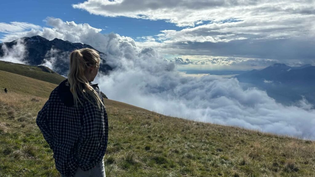 A lady staring the views of the clouds in Lake Garda.