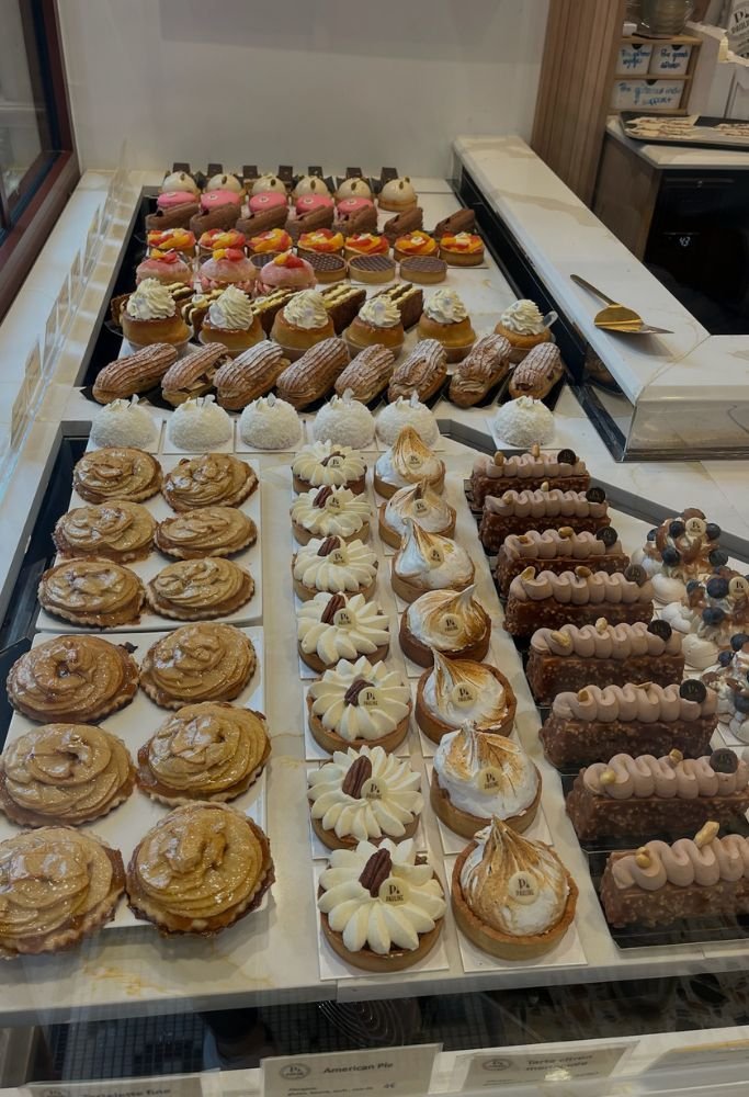 An elegant pastry shop displaying a variety of delicate desserts and confections.  Living in France as an American offers opportunities to savor desserts like these every day.