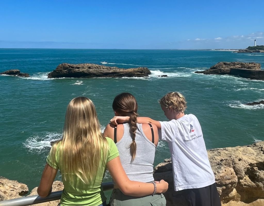 Children enjoying the scenic coastal views in France, but some bad things about living in France, like limited beach accessibility in crowded areas, can affect this experience.