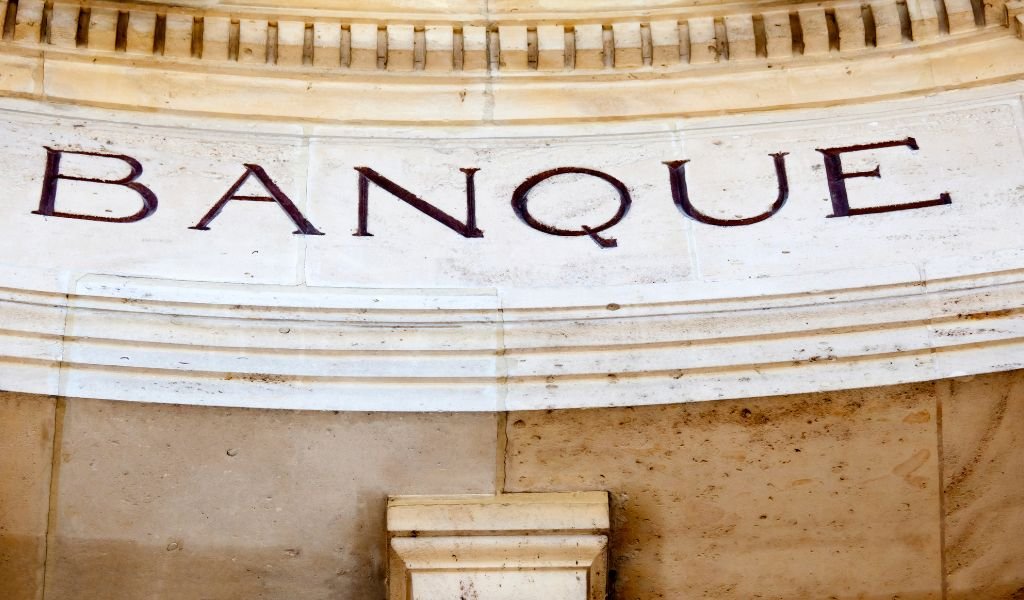 stone wall with the word "BANQUE" engraved in large letters, evoking a sense of permanence and stability in French banking