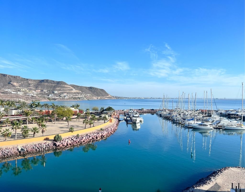 A peaceful waterfront view of a marina surrounded by stunning natural landscapes, reflecting Mexico’s coastal charm and raising the question, "Is It Safe to Move to Mexico?" Yes! It's very safe in many places.